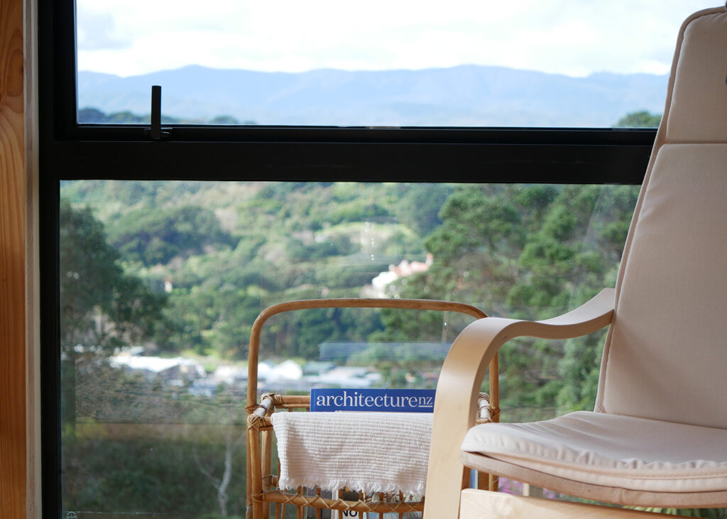 Armchair in window with view of hillside.